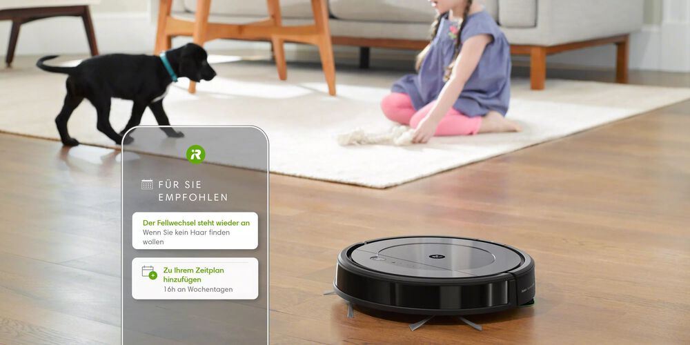 Ein Roomba mit einem Mädchen und einem haarenden Hund