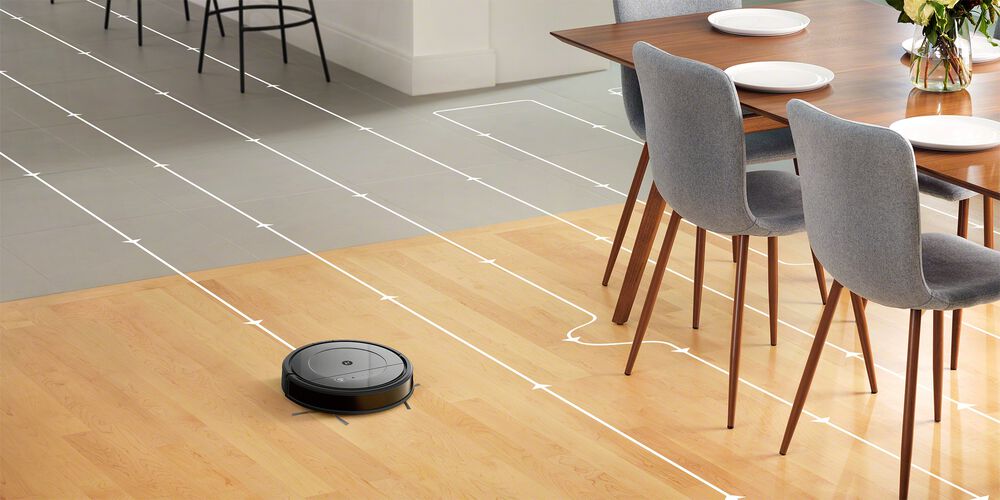 A Roomba cleaning a hardwood floor